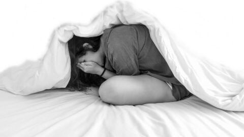 girl-hiding-under-blanket evil making her fearful