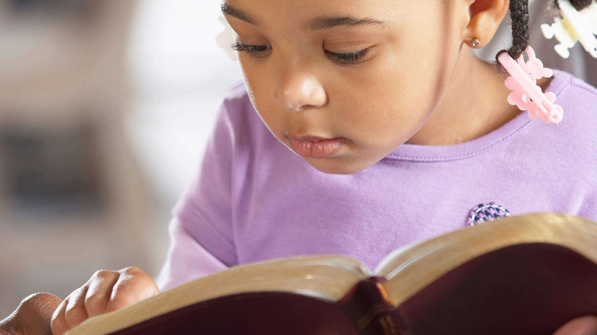 girl reading the bible to keep her soul continually satisfied