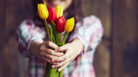 Girl giving tulips demonstrating it is better to give