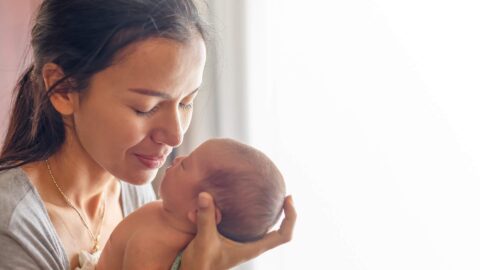 Woman holding her newborn demonstrating the power of God's love for us