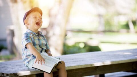 laughing boy reading bible demonstrating the joy of living for God