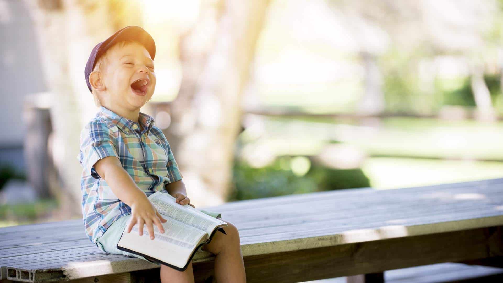 laughing boy reading bible demonstrating the joy of living for God