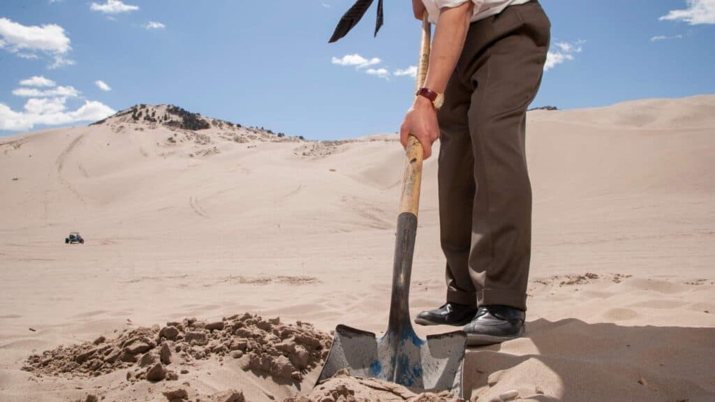 man burying offenses in the sand