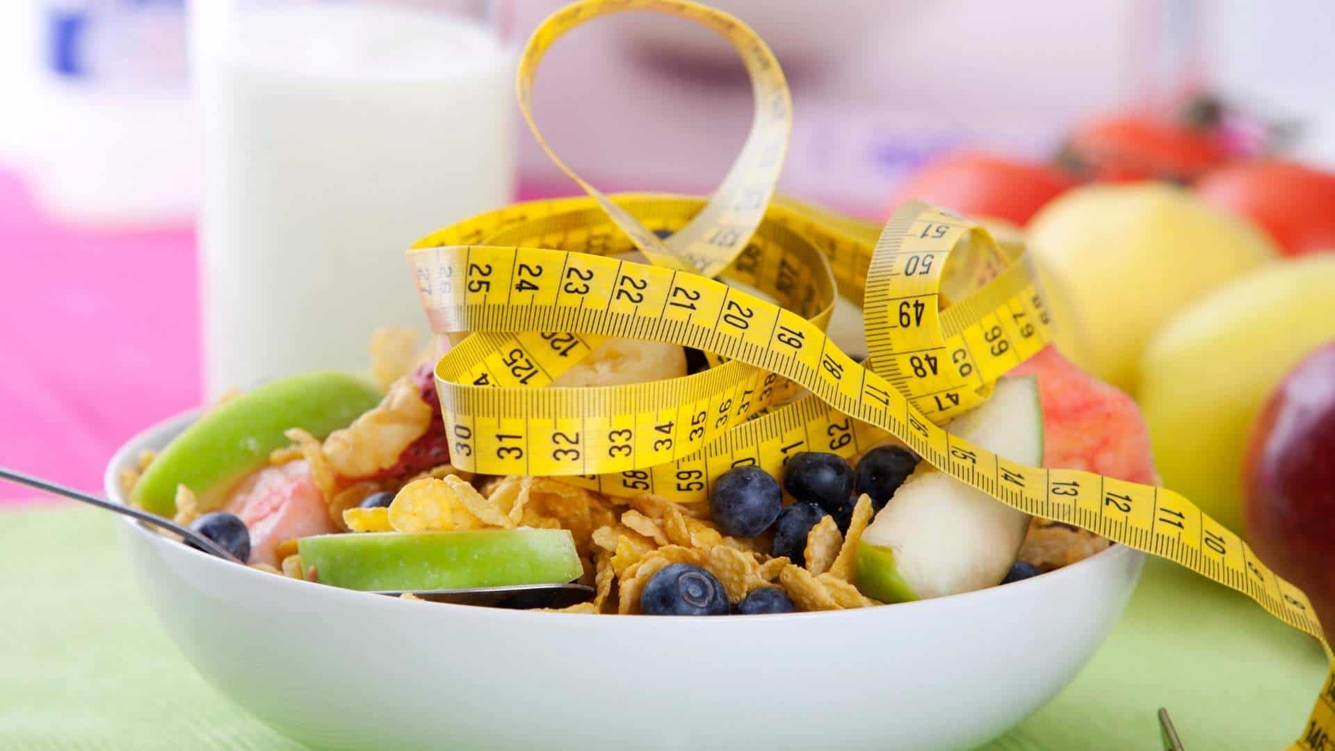 bowl of granola and measuring tape and dieting