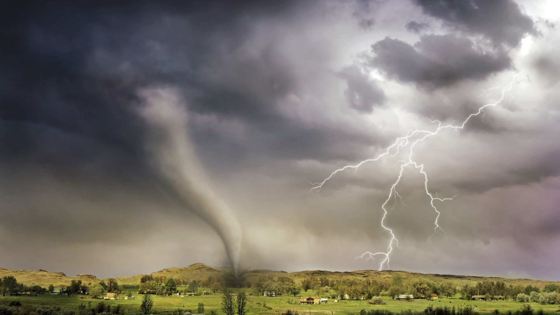 Image of a storm with a tornado hitting a valley