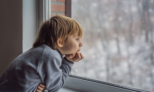 Boy watching snow fall