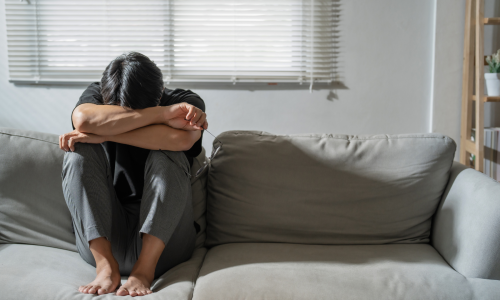 Man with arms on knees on couch