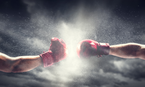 Two boxing gloves clashing