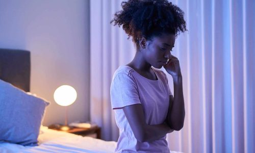 black girl sitting on bed