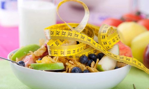 bowl of granola and measuring tape and dieting