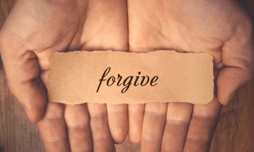 Hands holding the word "forgive"