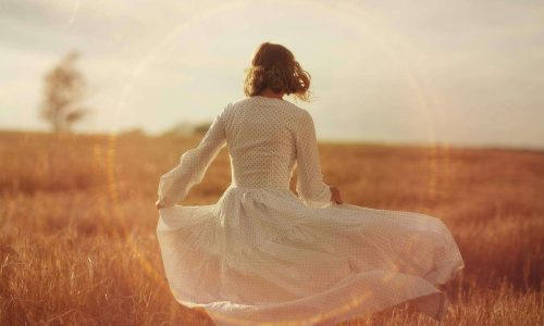 Girl in a field praying to God