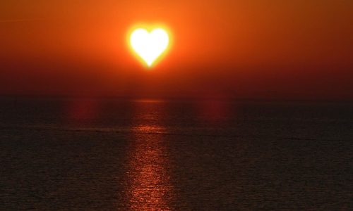 heart shaped sun over ocean