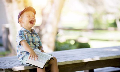 laughing boy reading bible demonstrating the joy of living for God