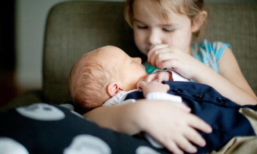 little girl holding baby