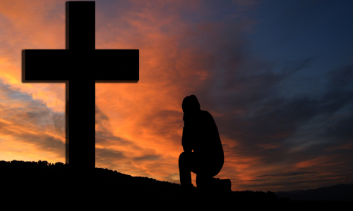 man kneeling before cross