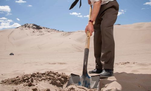 man burying offenses in the sand