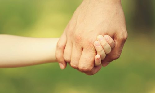 parent holding childs hand