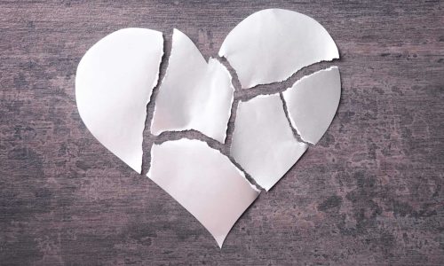 torn paper heart representing being crushed by heartbreak.