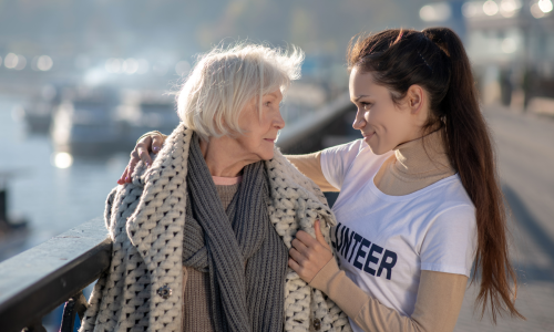 volunteer helping elderly woman