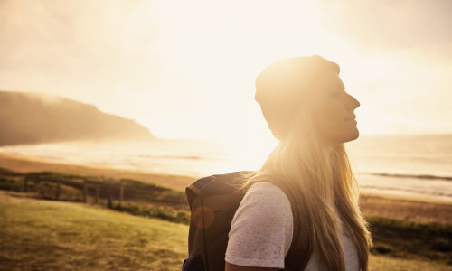 woman in field near ocean