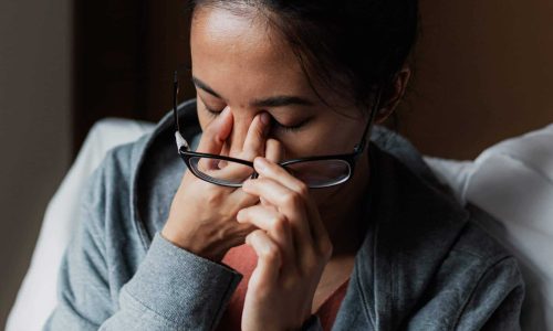 woman pinching nose with worry