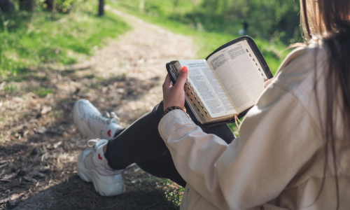 woman reading bible outside