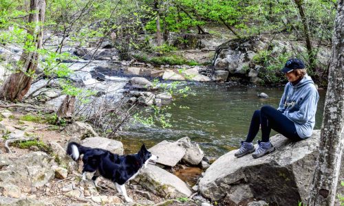 woman walking dog creek